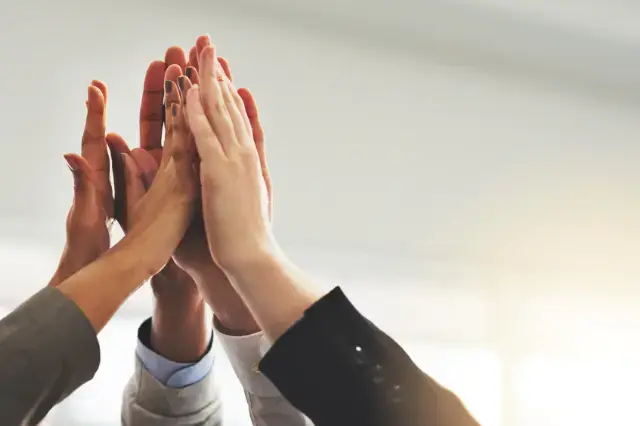 Team members high-fiving in unity.